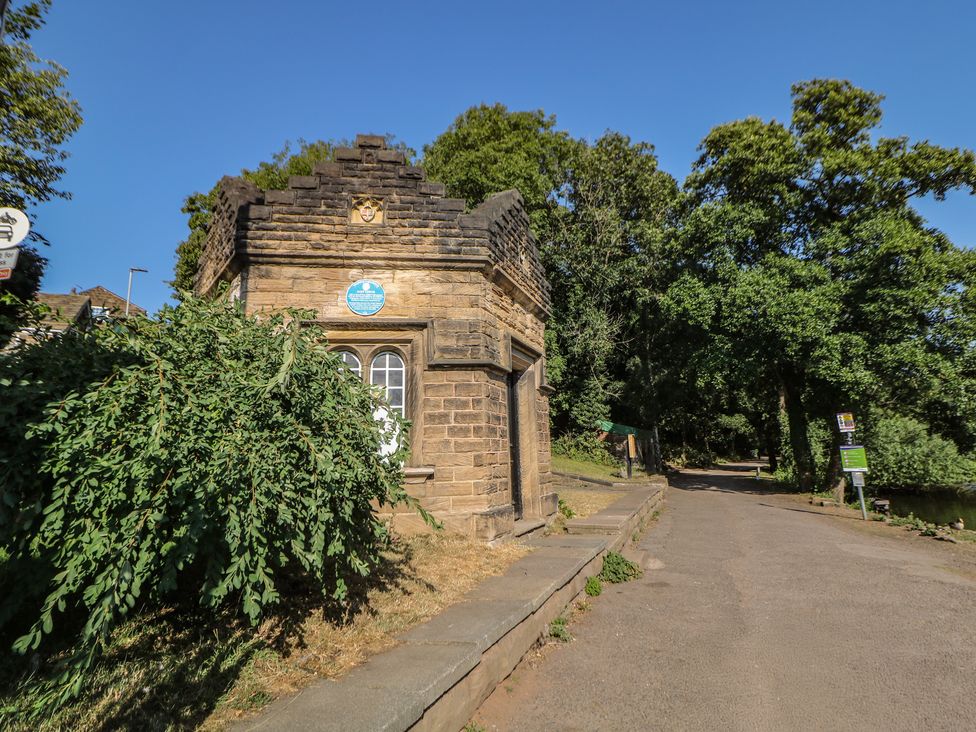 A stone building surrounded by trees at Lake Side Cottage Wakefield