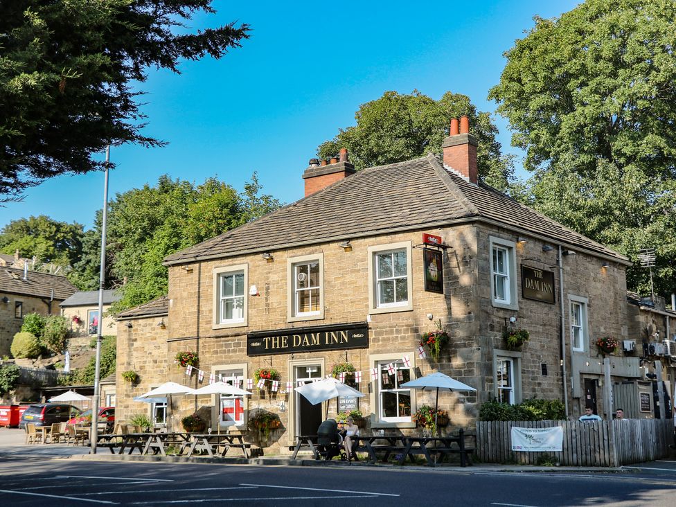 An outdoor view of The Dam Inn with seating and umbrellas in Wakefield