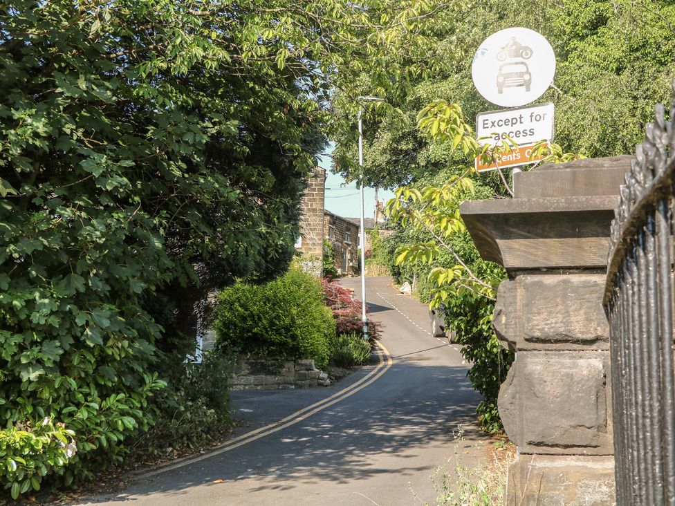 A road with trees and a sign at Lake Side Cottage Wakefield