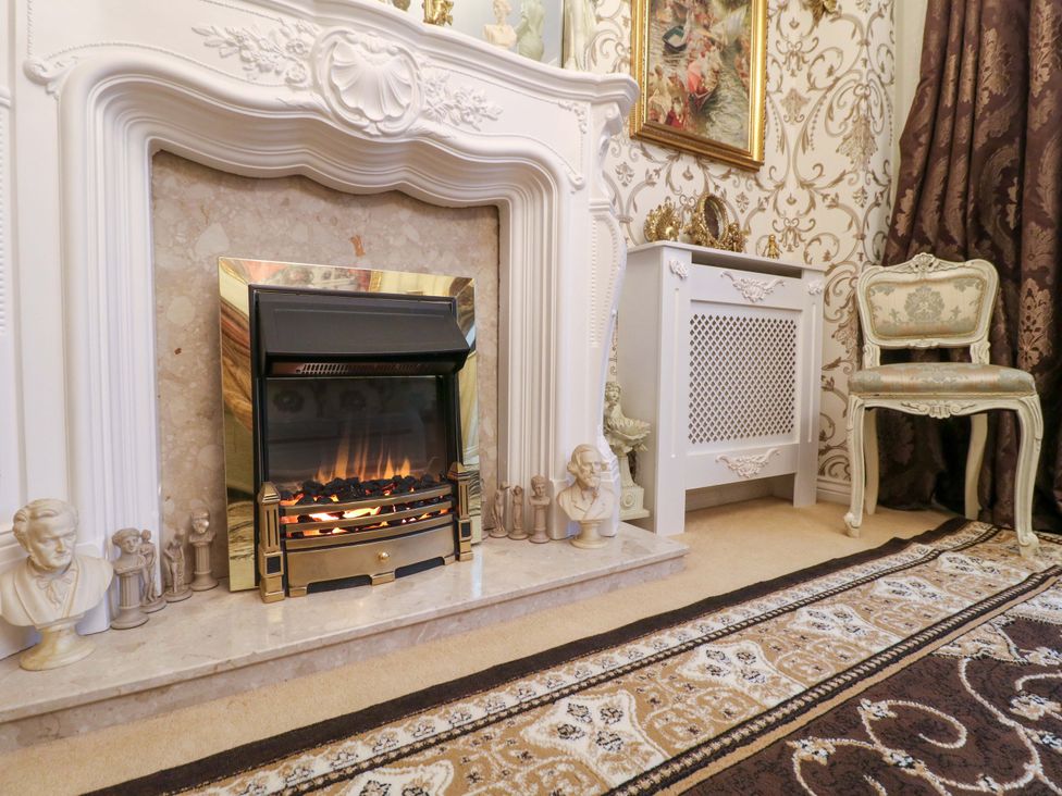 A living room with a fireplace and a chair at 41 Lower Birches Way Rugeley