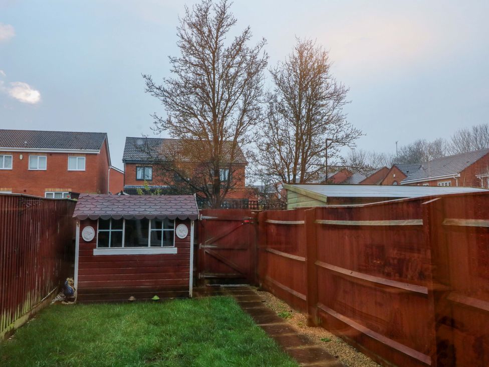 A garden with a wooden shed and trees at 41 Lower Birches Way Rugeley