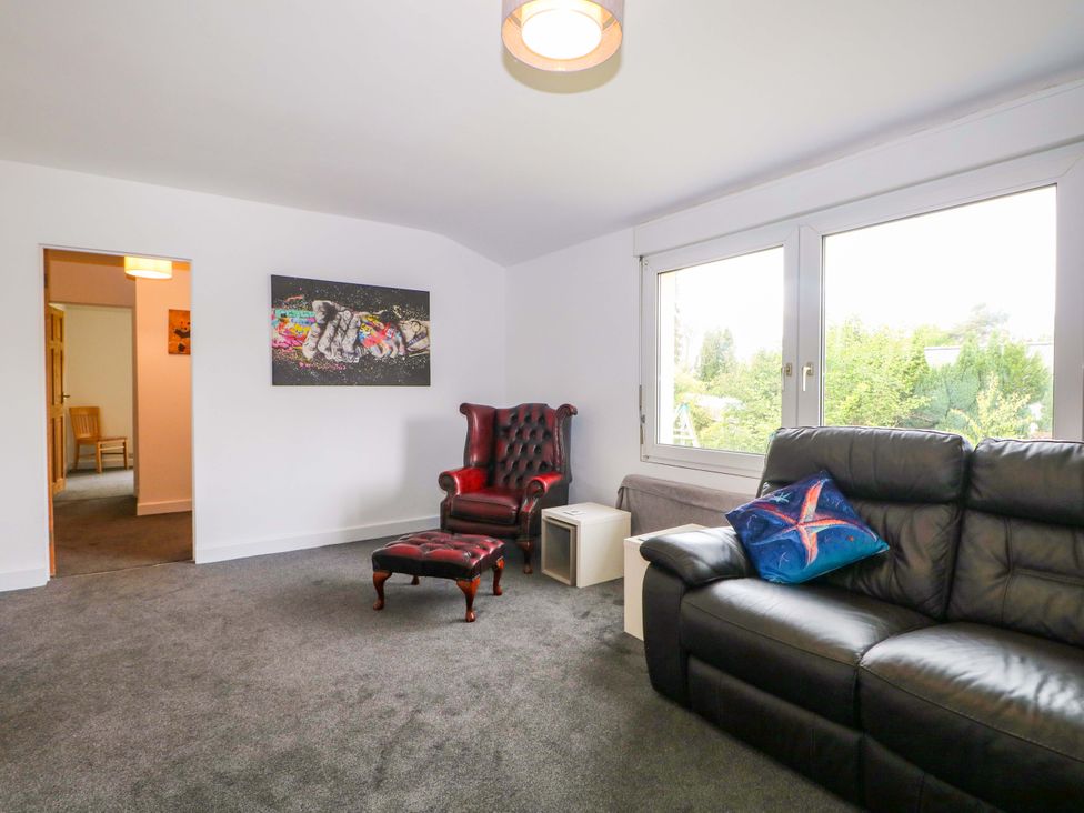 A living room with an armchair, sofa, and artwork at Woodside in Battle