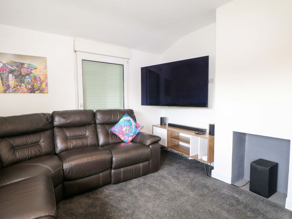 A living room with a sofa and television at Woodside in Battle