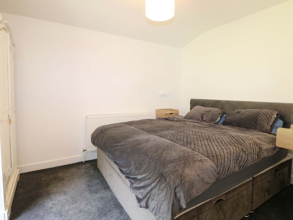 A bedroom with a bed and wardrobe at Woodside in Battle