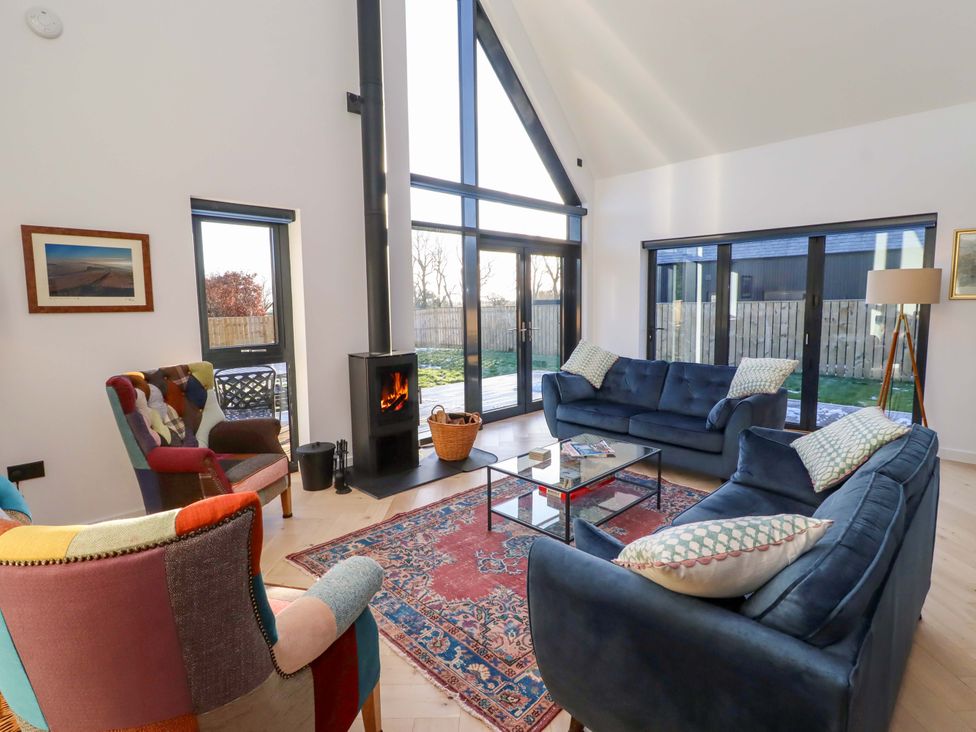 A living room with a sofa and fireplace at 1 Dairy Fields in Longframlington