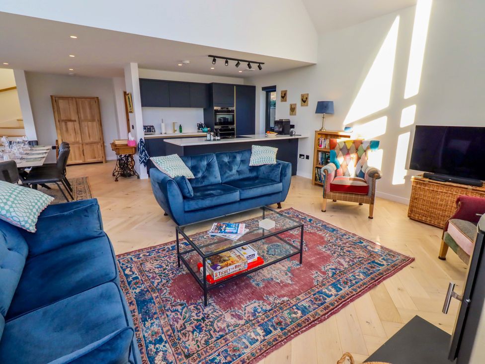 A living room with a sofa, coffee table, and television at 1 Dairy Fields Longframlington