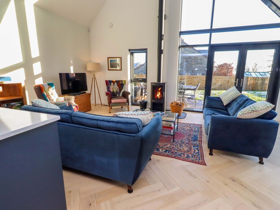 A living room with sofas and a fireplace at 1 Dairy Fields Longframlington