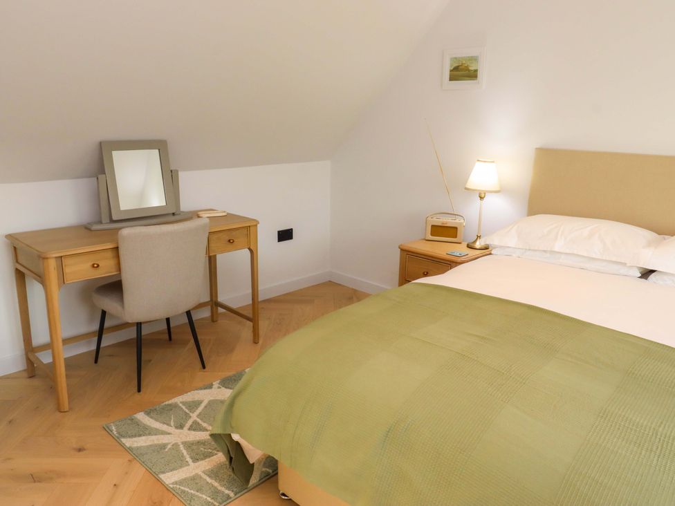 A bedroom with a bed and a desk at 1 Dairy Fields, Longframlington