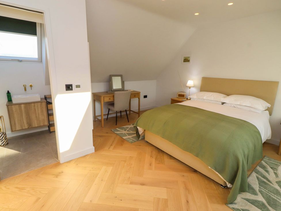 A bedroom with a bed and desk at 1 Dairy Fields Longframlington