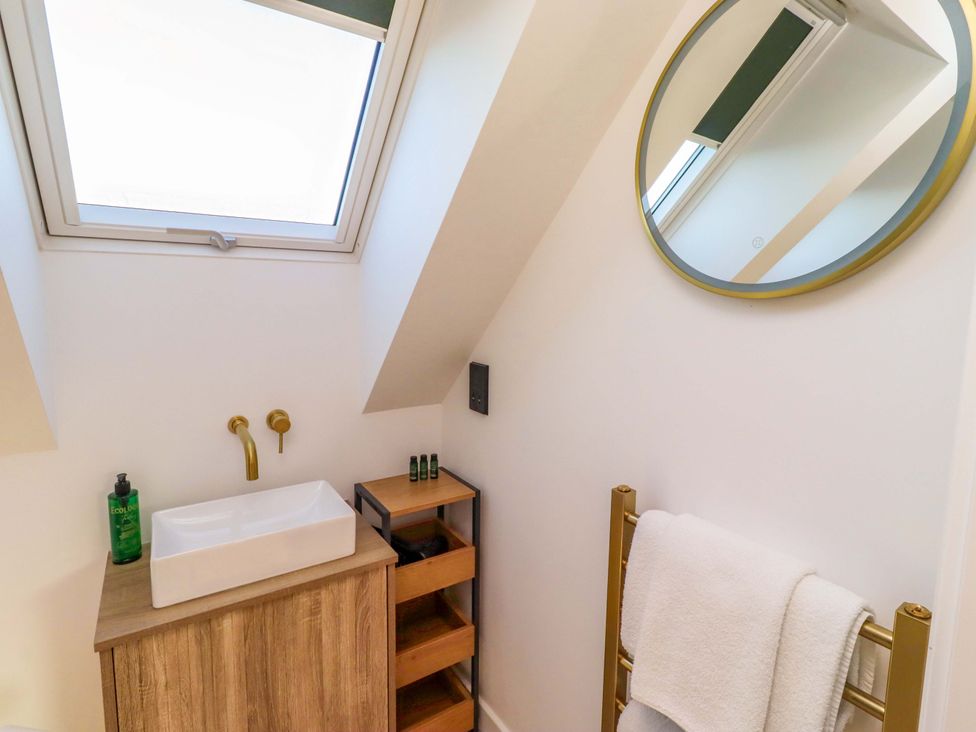 A bathroom with a wash basin and mirror at 1 Dairy Fields Longframlington