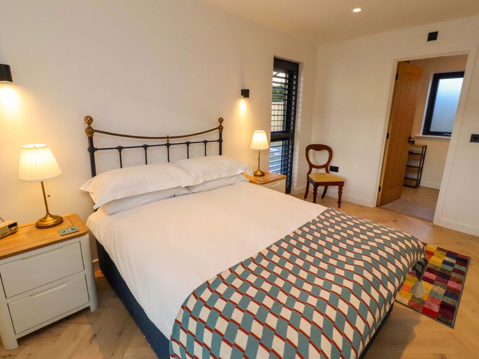 A bedroom with a bed and lamp at 1 Dairy Fields Longframlington