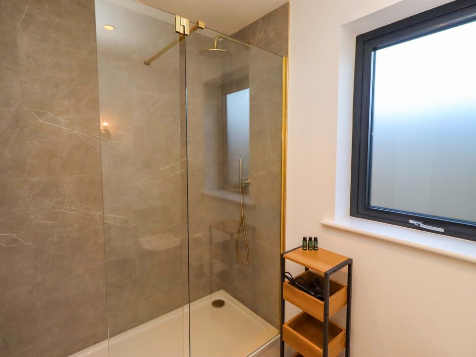A bathroom with a shower and window at 1 Dairy Fields in Longframlington