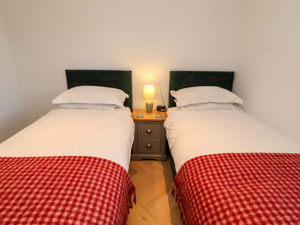 A bedroom with two single beds and a nightstand at 1 Dairy Fields, Longframlington