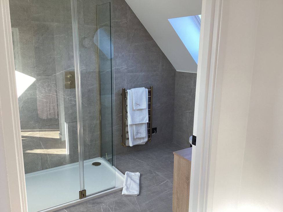 A bathroom with a shower and towel rail at The Barn in Longframlington