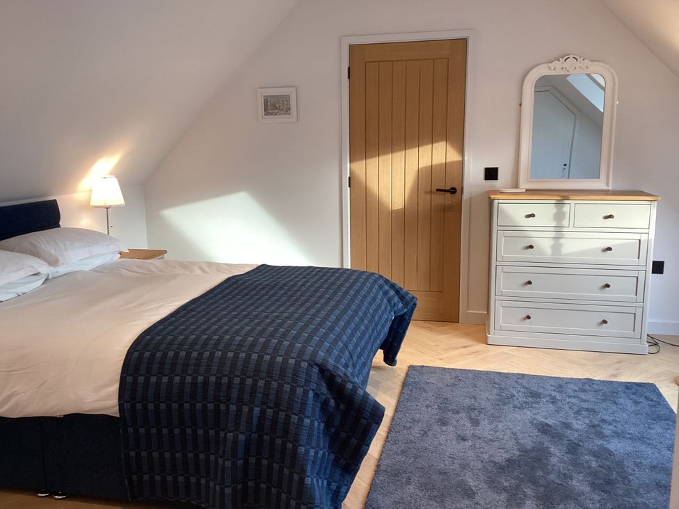 A bedroom with a bed and dresser at The Barn in Longframlington