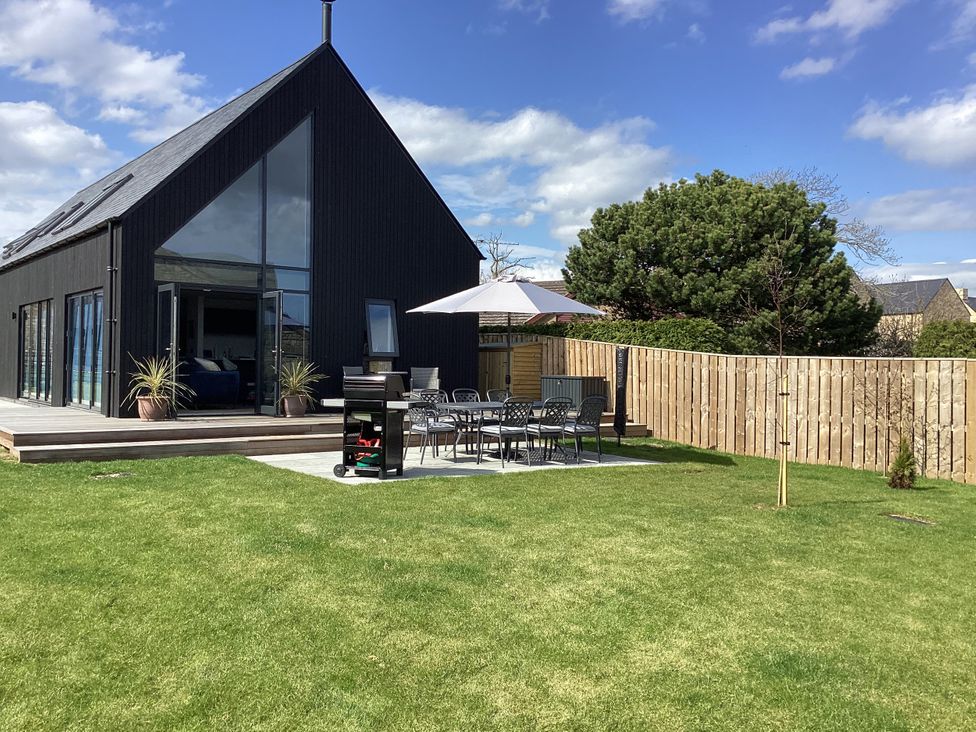 A garden with a patio table and chairs at The Barn in Longframlington