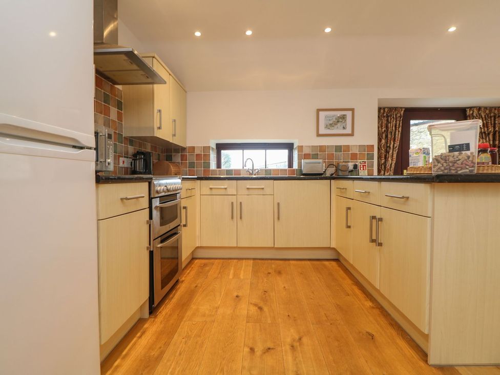 A kitchen with cabinets and appliances at Little Tregarrick in Helston