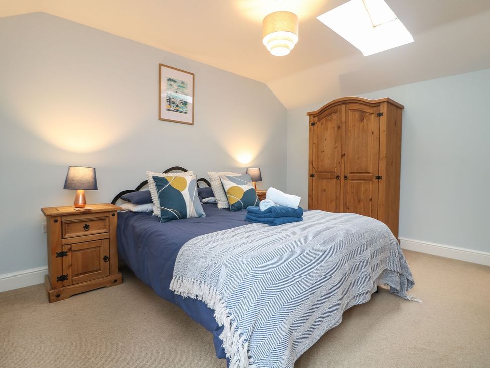 A bedroom with a bed and wardrobe at Little Tregarrick Helston
