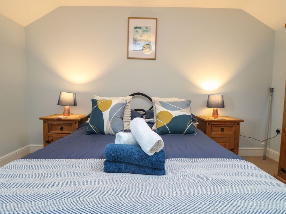 A bedroom with a bed and bedside tables at Little Tregarrick in Helston