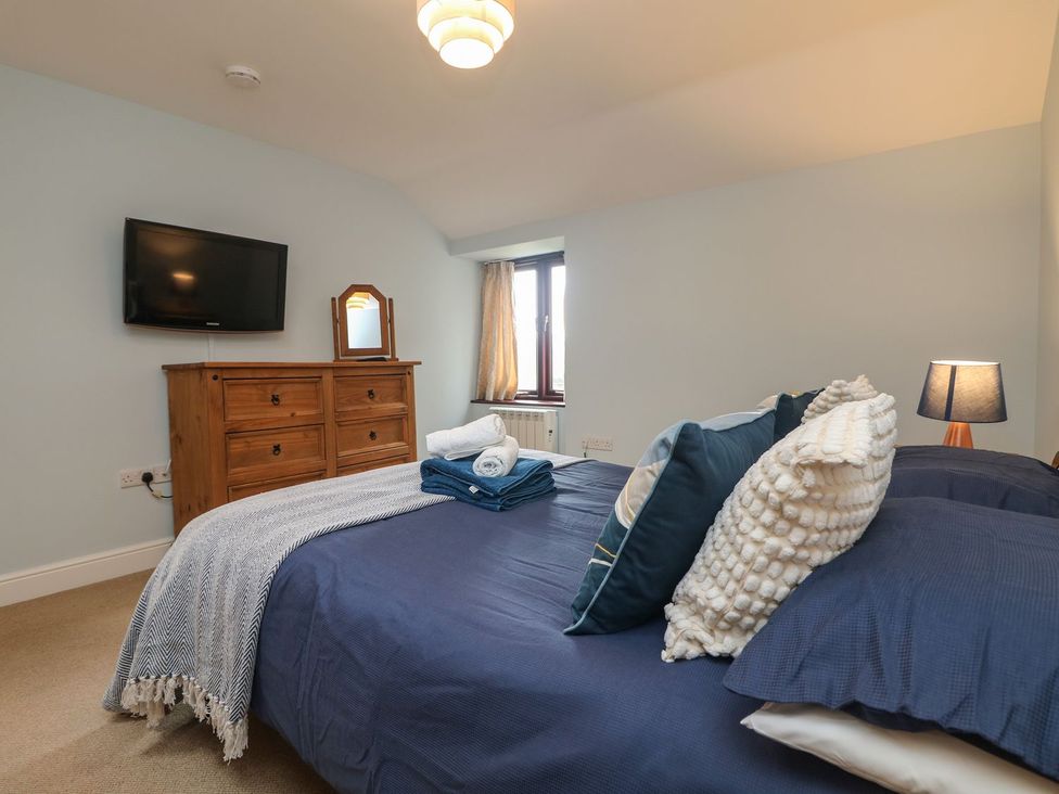A bedroom with a bed and a dresser at Little Tregarrick in Helston