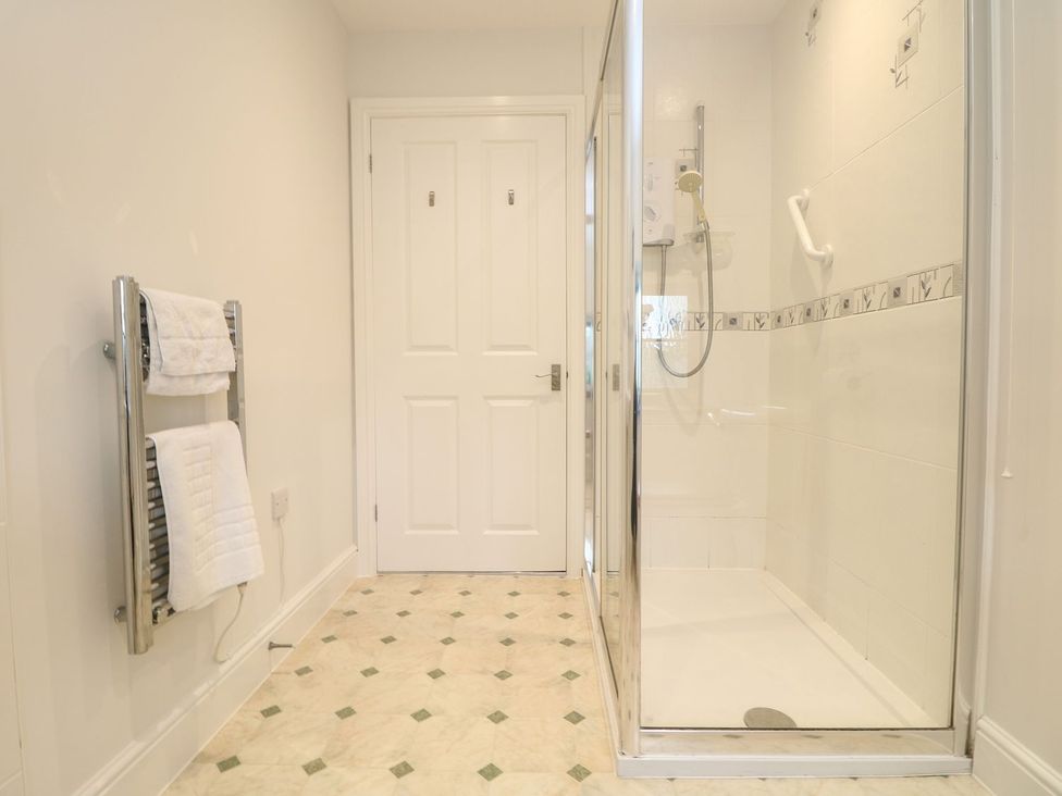 A bathroom with a shower and towel rail at Little Tregarrick in Helston
