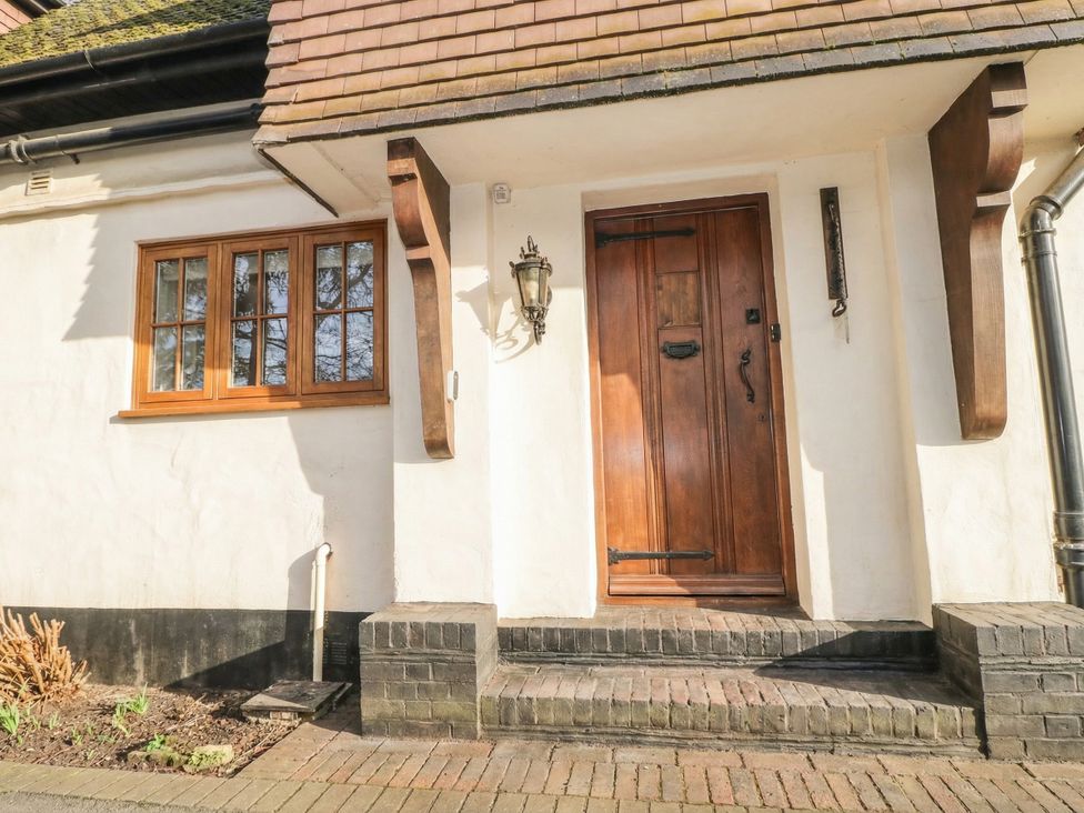 An entrance with a wooden door and window at Woodlands house in Ringwood