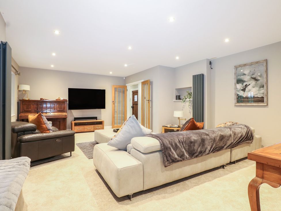 A living room with a piano and sofa at Woodlands house in Ringwood