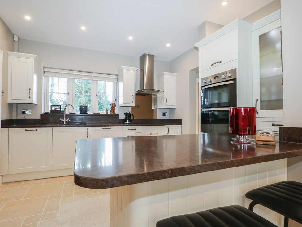 A kitchen with cabinets and a stove at Woodlands house in Ringwood