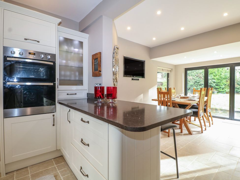 A kitchen with an oven and a dining area at Woodlands house in Ringwood