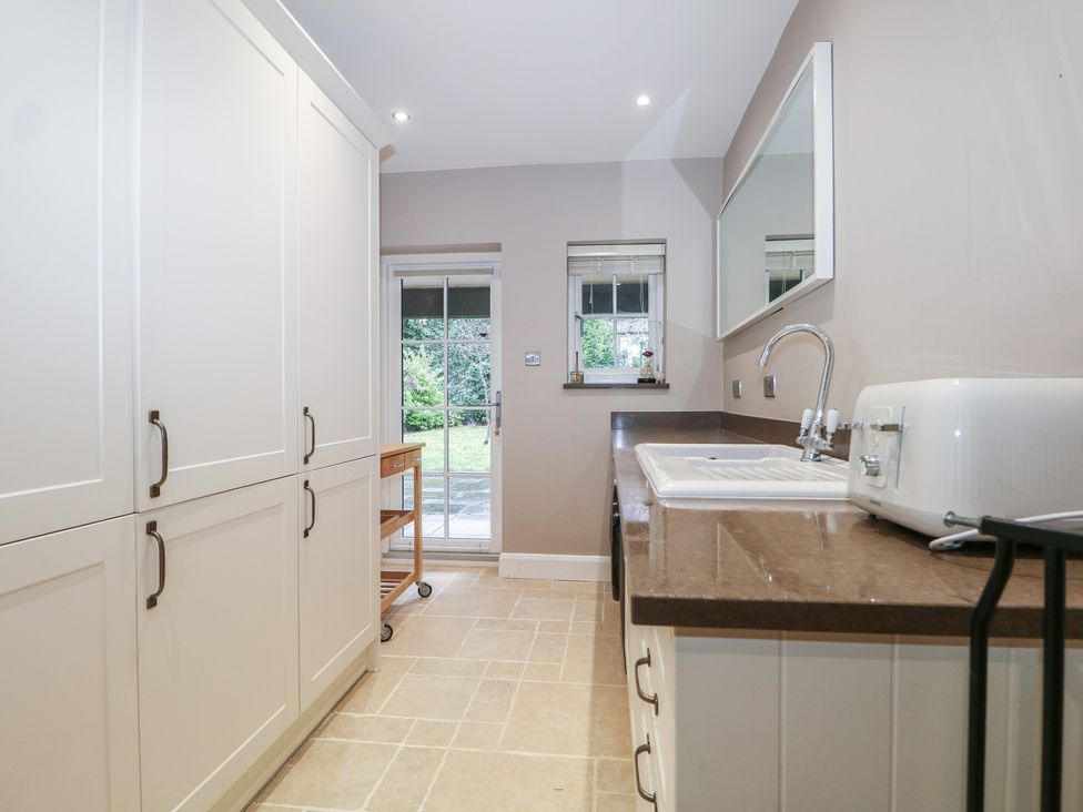 A utility room with cupboards and a sink at Woodlands house in Ringwood