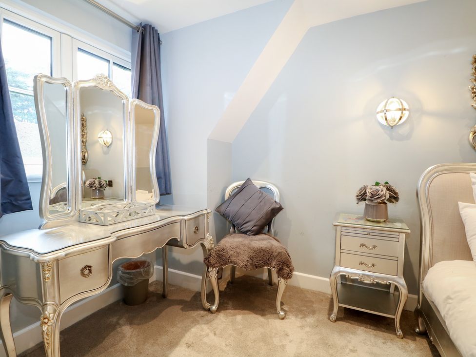 A bedroom with a vanity table and a chair at Woodlands house Ringwood