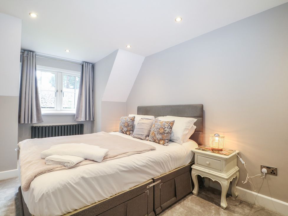 A bedroom with a bed and bedside table at Woodlands house in Ringwood