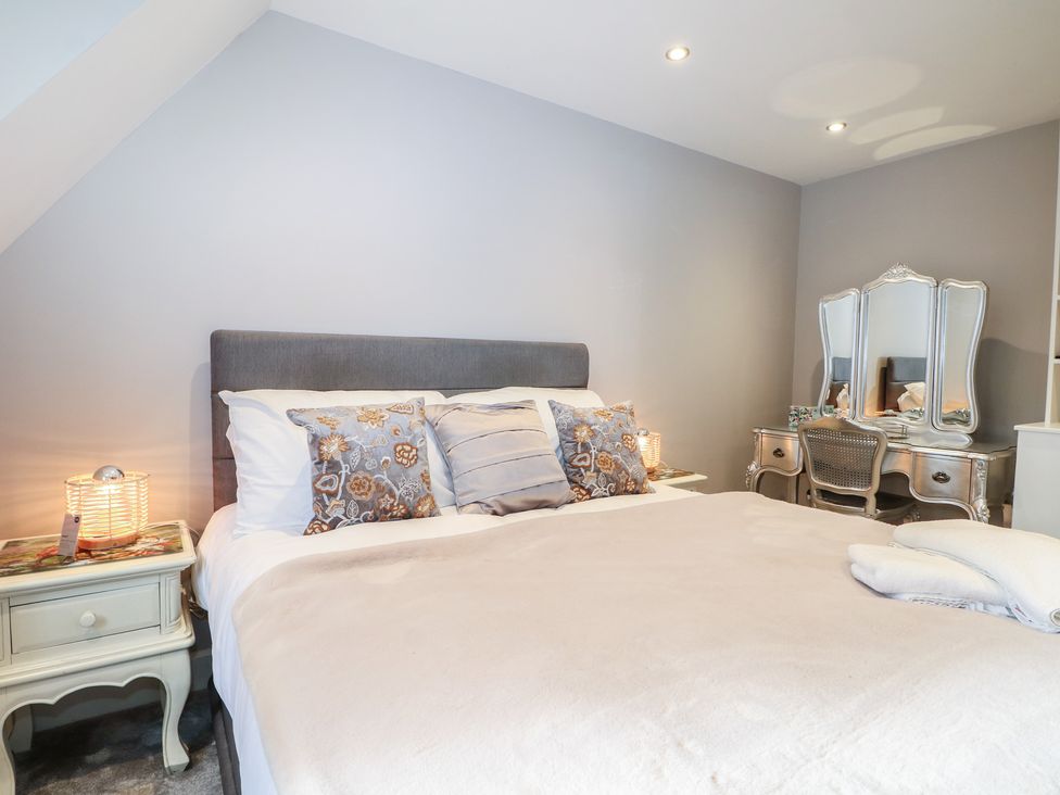 A bedroom with a bed and a dressing table at Woodlands house in Ringwood