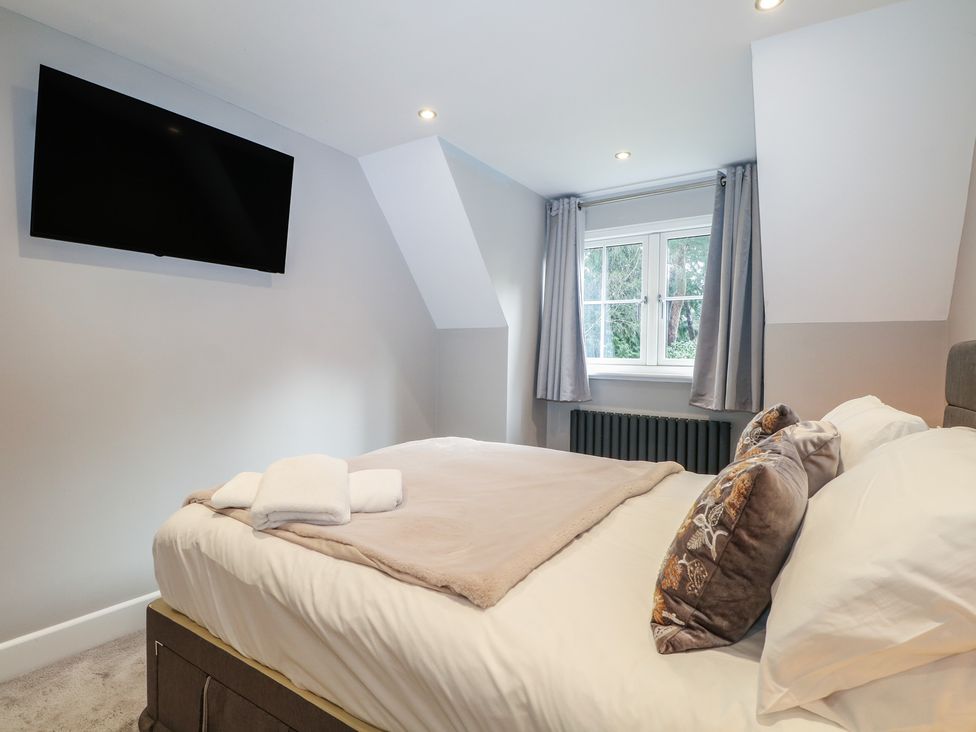 A bedroom with a bed and television at Woodlands house in Ringwood
