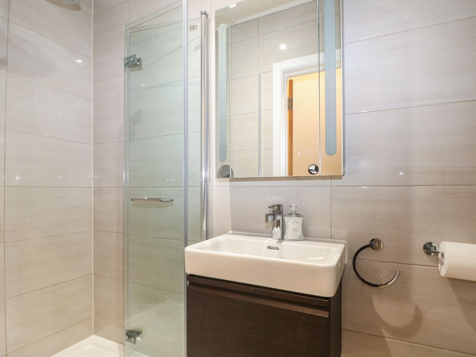 A bathroom with a shower and sink at Woodlands house in Ringwood
