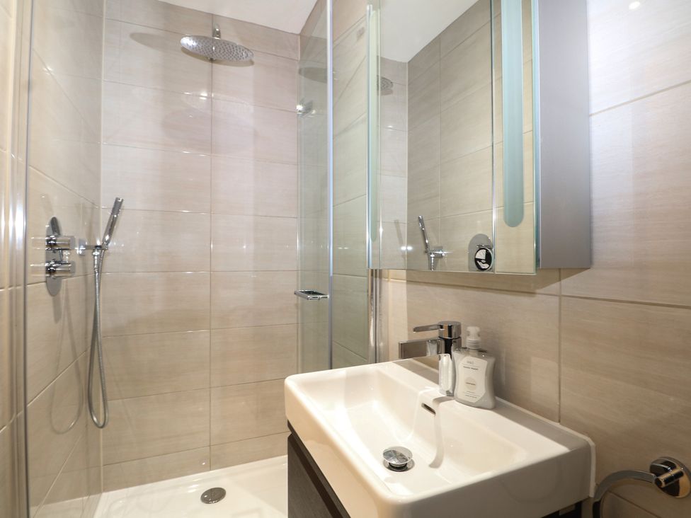 A bathroom with a shower and sink at Woodlands house Ringwood