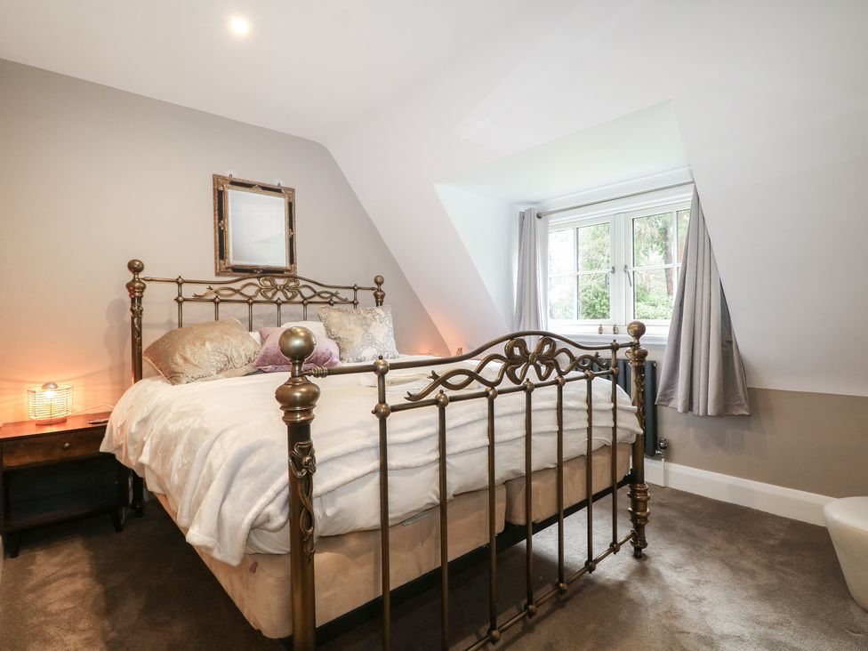 A bedroom with a bed and bedside table at Woodlands house in Ringwood