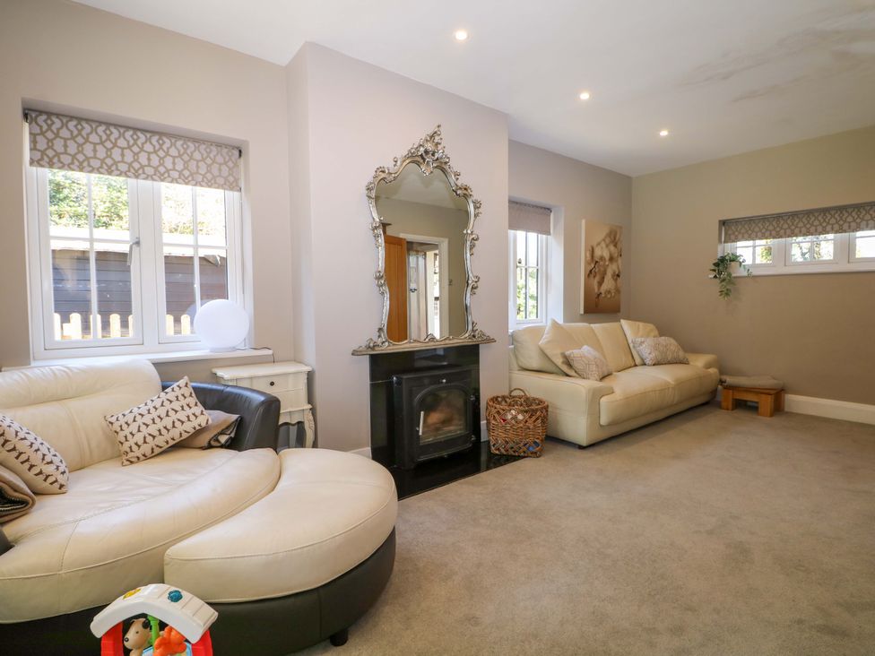 A living room with a sofa and fireplace at Woodlands House in Ringwood