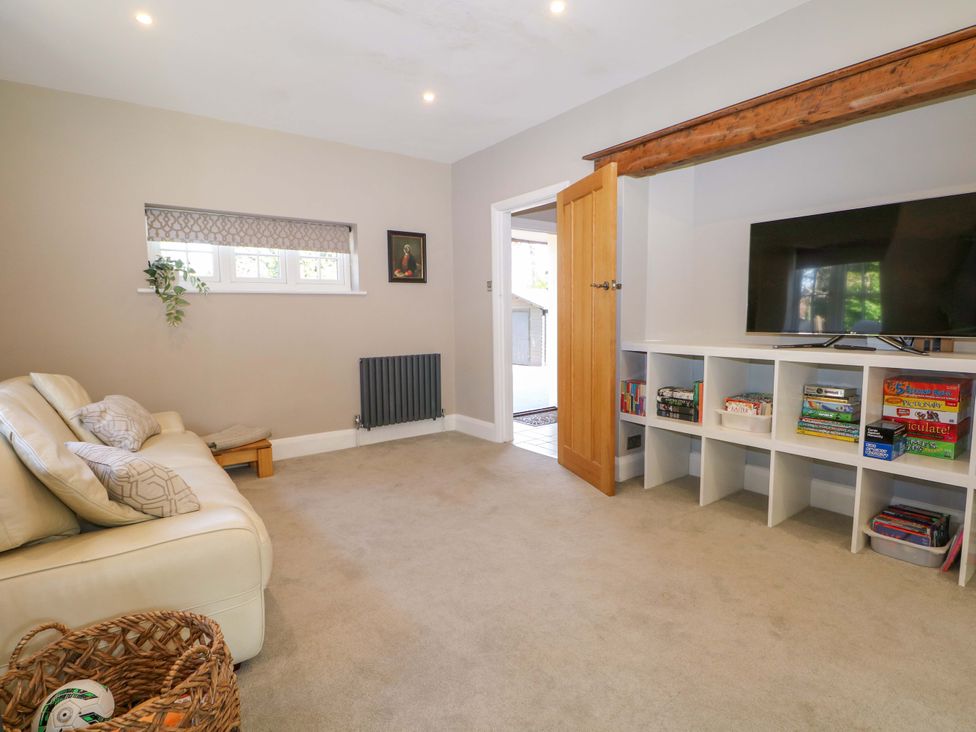 A living room with a sofa and television at Woodlands House in Ringwood