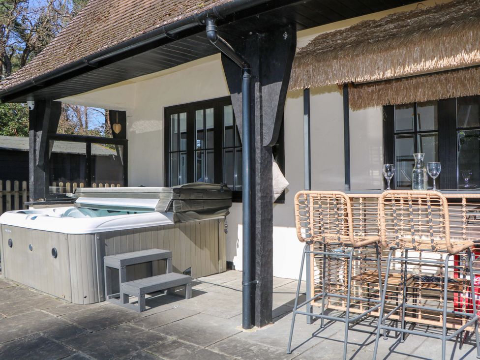 An outdoor area with a hot tub and a bar counter at Woodlands House in Ringwood