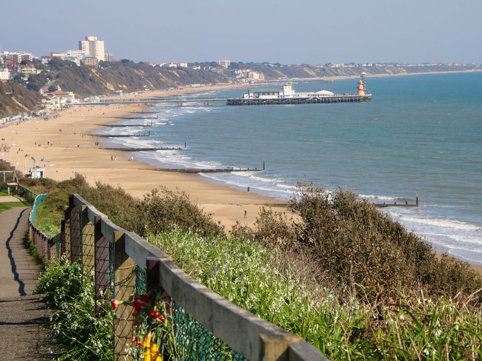 A beach with a pier and pathway at Woodlands House in Ringwood