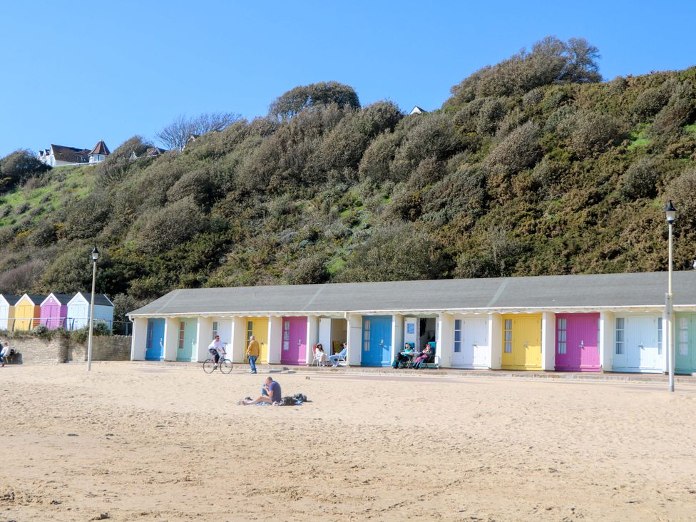 A row of beach huts and people at the beach at Woodlands House Ringwood