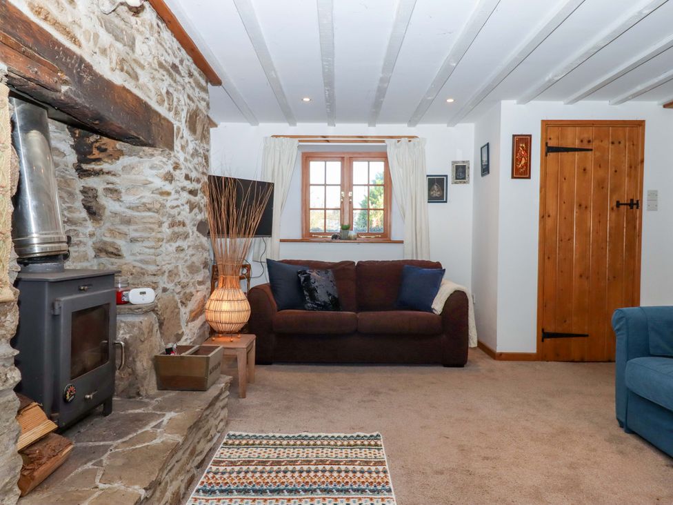 A living room with a sofa and fireplace at Park Cottage in Kingsbridge