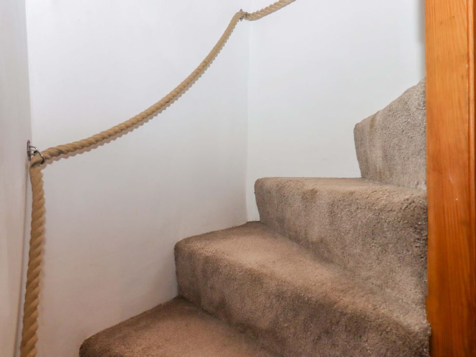A staircase with carpeted steps and a rope handrail at Park Cottage in Kingsbridge