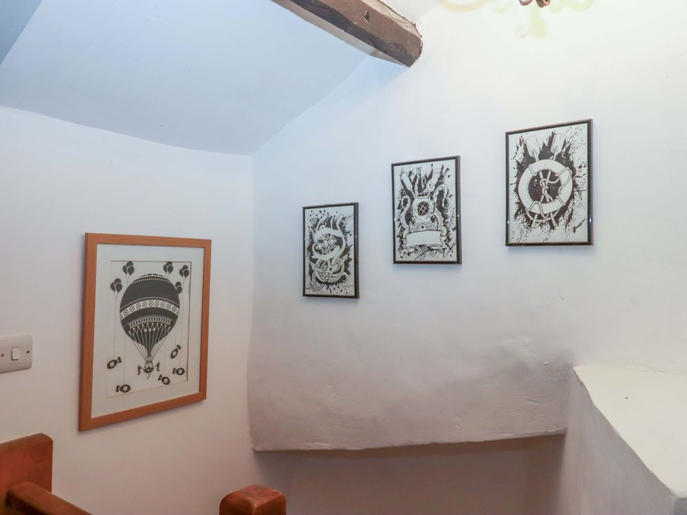 A staircase with framed art at Park Cottage in Kingsbridge