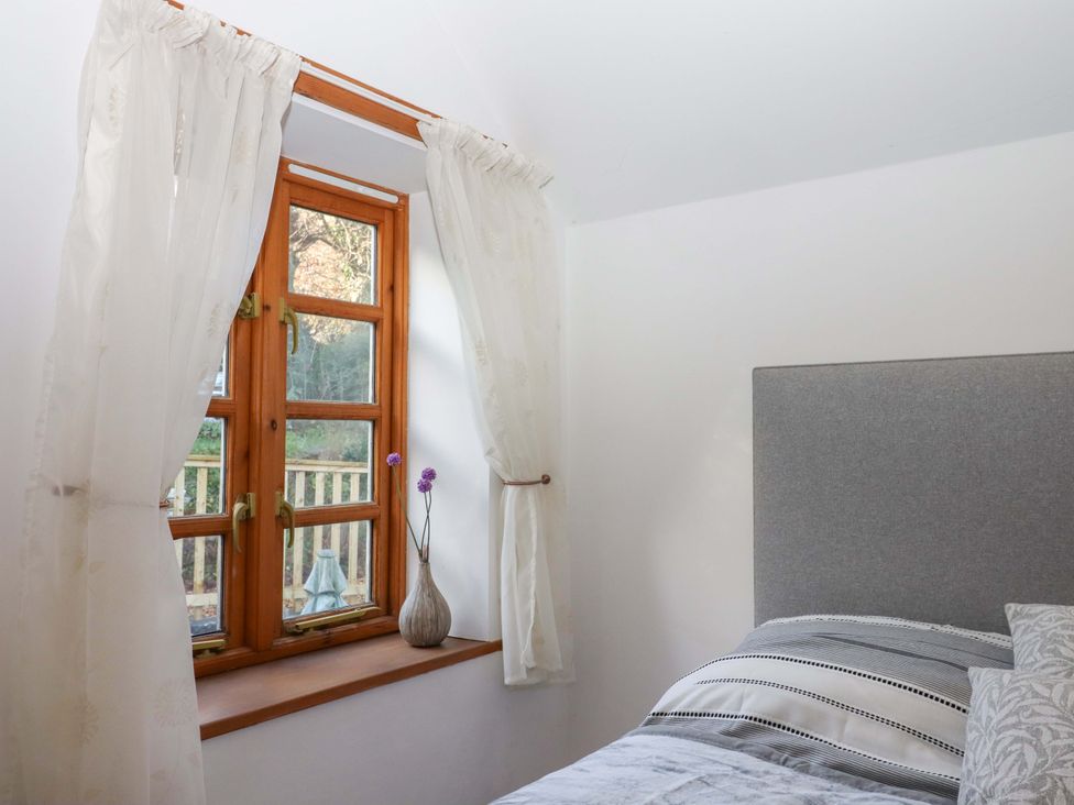 A bedroom with a window and bed at Park Cottage in Kingsbridge