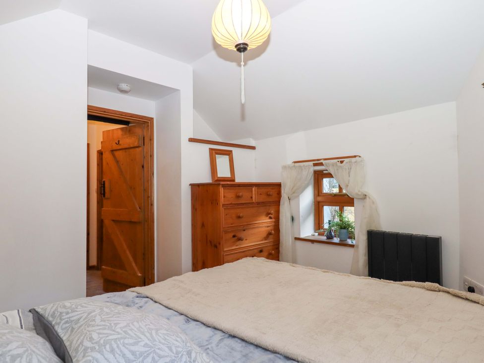 A bedroom with a bed and dresser at Park Cottage in Kingsbridge