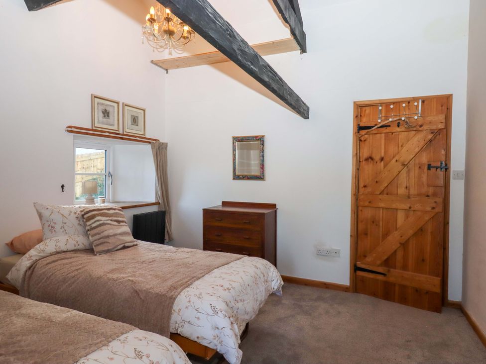 A bedroom with two beds and a chest of drawers at Park Cottage in Kingsbridge