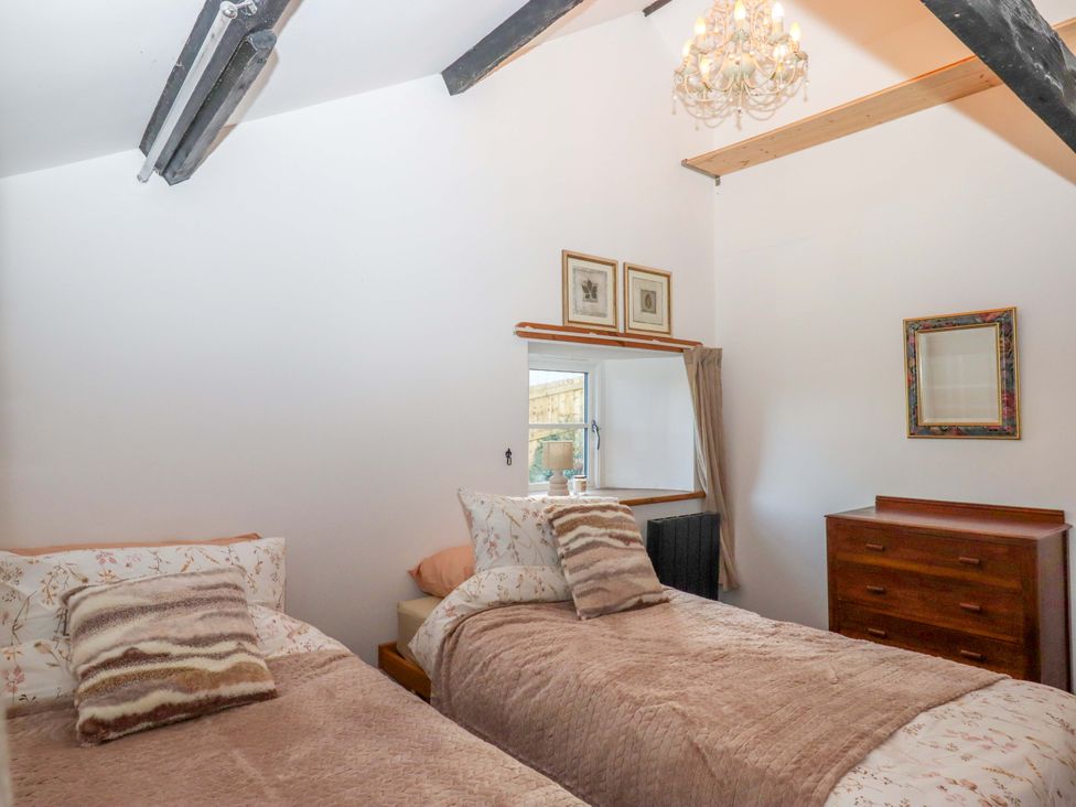 A bedroom with twin beds and a chest of drawers at Park Cottage in Kingsbridge
