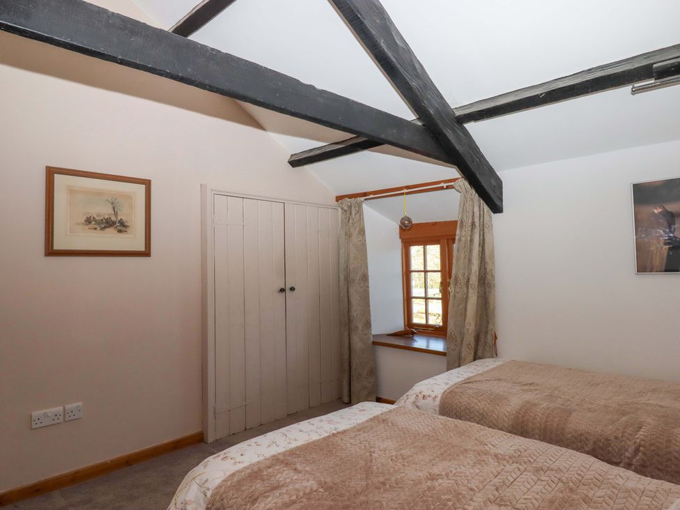 A bedroom with twin beds and a wardrobe at Park Cottage in Kingsbridge